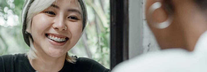 Periodontist Portland ME Young Woman with a Striped Beanie and Braces is Smiling while Consulting Young Woman with a Striped Beanie and Braces is Smiling while Consulting